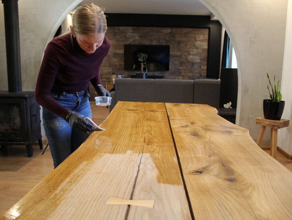 Zestaw do olejowania mebli drewnianych - nakładanie oleju na drewno pędzlem podczas olejowania powierzchni